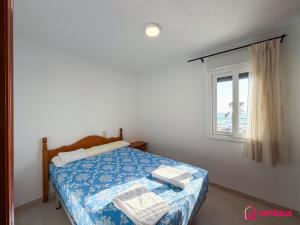 a small bedroom with a bed with a window at Poble Mar 2 in Oropesa del Mar