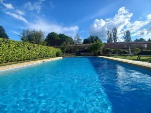 a large swimming pool with blue water at Hotel La Maison des Peyrat in Sarlat-la-Canéda