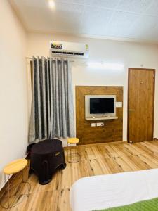 a room with a bed and a flat screen tv at Sirtaj Suites in Tājganj +19 photos