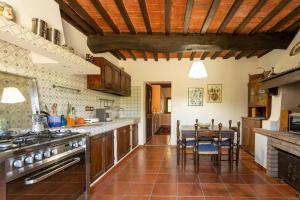 a kitchen with wooden cabinets and a table with chairs at Casale Bianca Luce in Santa Luce