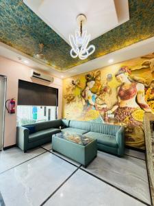 a living room with a couch and a mural at Sirtaj Suites in Tājganj