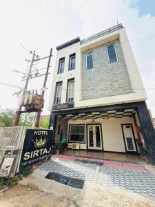 a building with a sign in front of it at Sirtaj Suites in Tājganj