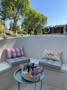 a patio with two couches and a table at Bateau Erebus - Bohême chic in Narbonne