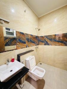 a bathroom with a white toilet and a sink at Sirtaj Suites in Tājganj