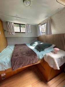 a bed in the middle of a small room at Bateau Erebus - Bohême chic in Narbonne