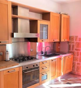 a kitchen with wooden cabinets and a stove top oven at Viale Monza Chic Stay - Affitti Brevi Italia in Milan