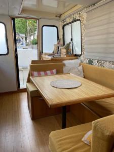 a dining room with a wooden table and chairs at Bateau Erebus - Bohême chic in Narbonne