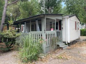 a small white tiny house with a porch at Mobile Home Agde Les Sables D'or in Le Grau-dʼAgde