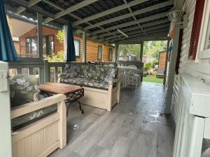 a screened in porch with couches and a table at Mobile Home Agde Les Sables D'or in Le Grau-dʼAgde