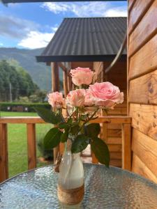 a vase filled with pink roses sitting on a table at San Marcos Mountain Lodge in Chontabamba