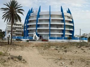 a blue building with a palm tree in front of it at Kmayra Diamond in Harqalah