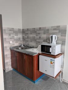 a kitchen with a microwave and a sink at Mirage in Tarrafal