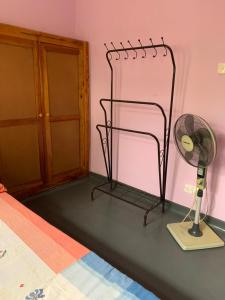 a room with a fan next to a pink wall at Emerald canopy retreat in Kandy