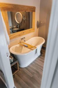 a bathroom with a white tub and a mirror at Yorebridge House in Bainbridge +11 photos