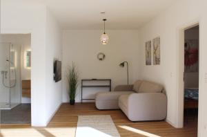 a living room with a couch and a tv at Glöckle Mühle, Ferienwohnungen und Camping mit Sauna in Herbolzheim