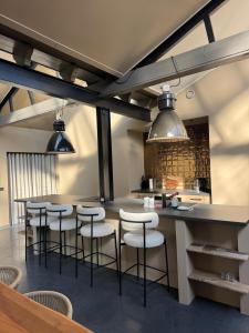 a kitchen with a bar with stools and a counter at Schuurwoning in Weert