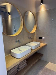 a bathroom with two sinks and two mirrors at Schuurwoning in Weert +15 photos