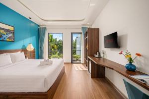 a bedroom with a bed and a desk with a tv at Flora Hoi An Lantern Town in Hoi An +34 photos