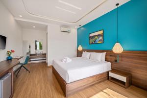 a bedroom with a white bed and a blue wall at Flora Hoi An Lantern Town in Hoi An