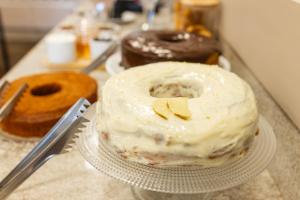 a cake on a plate on a counter with donuts at Hotel Somensi in Bento Gonçalves