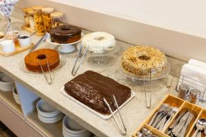 a counter with different types of cakes and pastries at Hotel Somensi in Bento Gonçalves