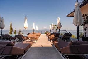 a row of chairs and umbrellas on a patio at Inex Olgica Hotel & SPA in Ohrid