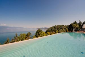a large swimming pool with a view of the water at Inex Olgica Hotel & SPA in Ohrid