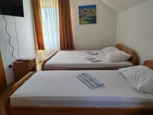two beds in a hotel room with towels on them at Vila Cezar in Gornja Toplica