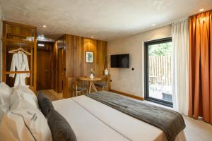 a bedroom with a large bed and a large window at Passinhos House in Amarante