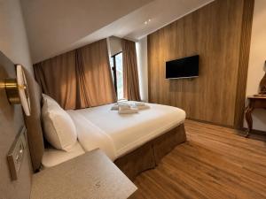 a hotel room with a bed and a flat screen tv at Mountain View Hot Spring Resort in Alamedin