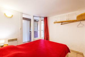 a room with a red bed and a window at Appartement de charme en Ardèche in Aubenas