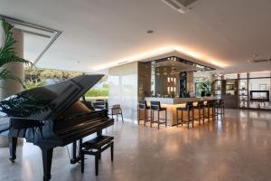 a piano in a living room with a dining room at Smy Pisa Plaza in Pisa