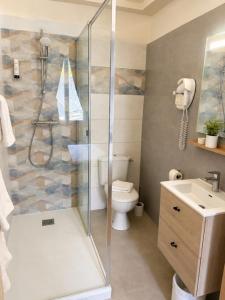 a bathroom with a shower and a toilet and a sink at Hotel de la Sologne in Beaugency