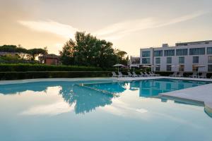 a swimming pool with chairs and a building at Smy Pisa Plaza in Pisa +156 photos
