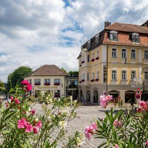 a group of buildings with flowers in the foreground at Der Platengarten in Ansbach