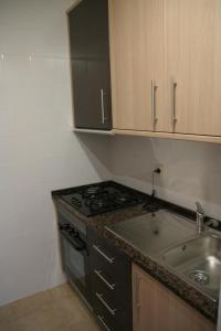 a kitchen with a stove and a sink at Pedras Del Rei Holiday House in Tavira