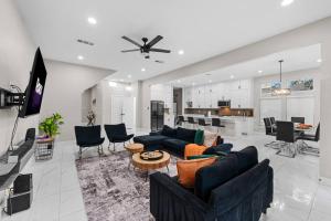 a living room with blue couches and a kitchen at Lux, Fenced Backyard 4 Pets, Firepit, Exec Desk in Dallas