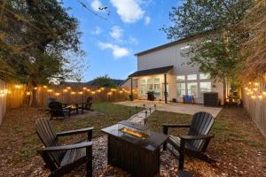 a backyard with chairs and a table and a fence at Lux, Fenced Backyard 4 Pets, Firepit, Exec Desk in Dallas