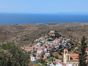 a village on a hill with the ocean in the background at Theros House in Ioulis +8 photos