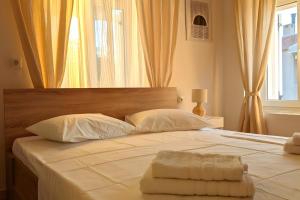 a large white bed with two pillows and a window at Theros House in Ioulis