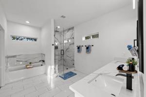 a white bathroom with a shower and a sink at Lux, Fenced Backyard 4 Pets, Firepit, Exec Desk in Dallas +55 photos