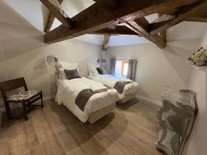 two beds in a room with wooden ceilings at Domaine de la Briouse in Sanxay +80 photos