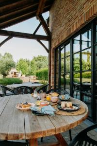 a wooden table with food on it on a patio at Casa Cava B&B in Dendermonde +68 photos