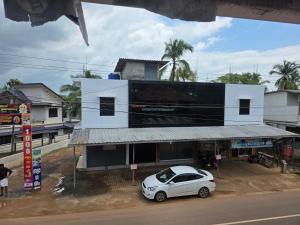 a white car parked in front of a building at Ruby Residency in Perintalmanna