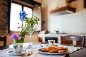 a table with a plate of cookies and a wine glass at Tenuta La Selva Casa Pendio in Casal Velino