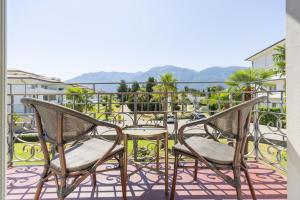 a pair of chairs and a table on a balcony at Villa Delta - Parkhotel Delta in Ascona