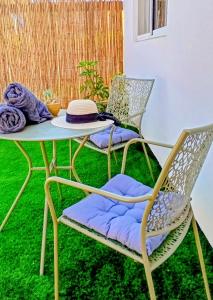 two chairs and a table with a hat on it at פינה בנחלה in Ma'ale Gamla