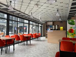 a restaurant with red chairs and tables and windows at Edelweiss 2 in Bosteri