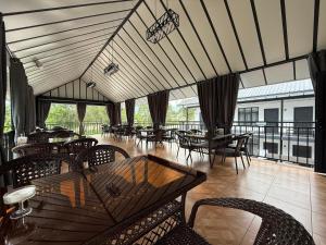 a dining room with tables and chairs on a balcony at Edelweiss 2 in Bosteri +23 photos