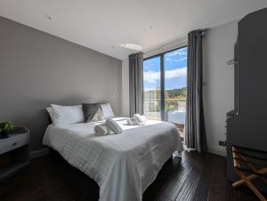 a bedroom with a white bed with a large window at Casa Brighouse in Brighouse +19 photos